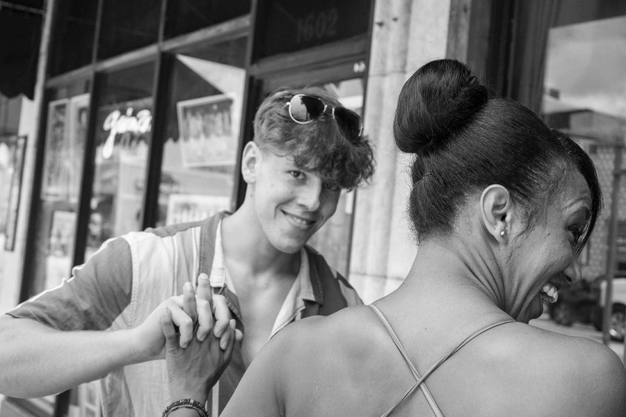 Two people laughing on a Little Havana sidewalk, black and white