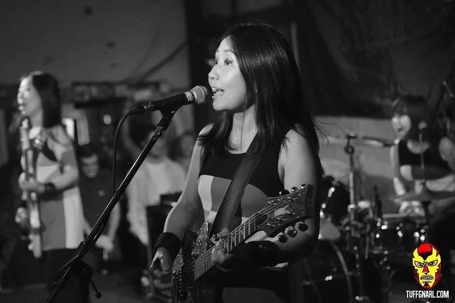 Shonen Knife singing and playing bass on stage in Miami
